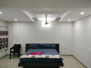 a bedroom with a bed and a chair in it at Hotel Jaganmatha Kollur in Kollūru