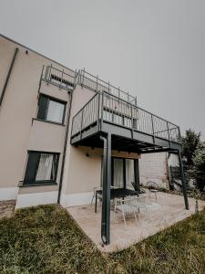 a building with a balcony with tables and chairs at Batu Apartment in Viernheim