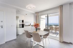 a kitchen and dining room with a table and chairs at AT Ponent VI in Oliva