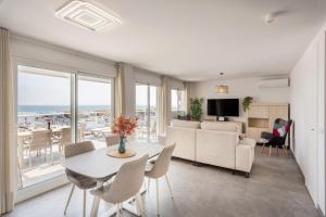 a living room with a couch and a table with chairs at AT Ponent VI in Oliva