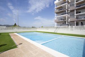 a swimming pool in front of a building at AT Ponent VI in Oliva