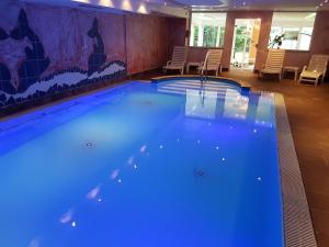 a large swimming pool in a room with chairs at Land-gut-Hotel Zum alten Forsthaus - Aufladestation für Elektroautos in Hürtgenwald