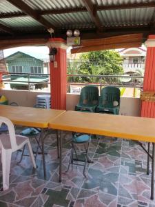 a row of tables and chairs on a balcony at Vhauschild Transient Rooms in Alaminos