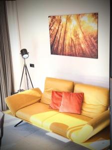 a yellow couch with two red pillows in a room at Aenna Apart Prutz in Prutz