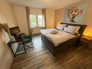 a bedroom with a bed and a desk with a laptop at Moderne Wohnung mit Parkplatz und Kaffeevollautomat in Zülpich