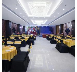 a banquet hall with yellow tables and black chairs at Hotel Diamond Villa and Banquet in Amritsar
