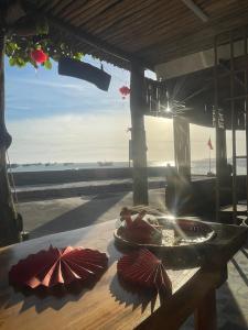 a wooden table with umbrellas on the beach at Chunlii Homestay in Ke Ga