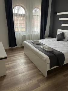 a bedroom with a large white bed and two windows at loopy lodge hotel in Ürgüp