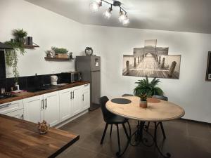 a kitchen with a table and a table and chairs at HAPPY SPA in Gouy-en-Gohelle