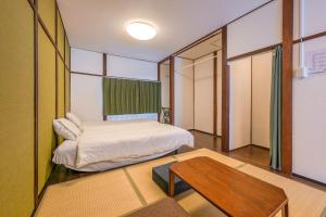 a small bedroom with a bed and a table at YAGARA TERRACE HOUSE OSAKA Room D in Osaka