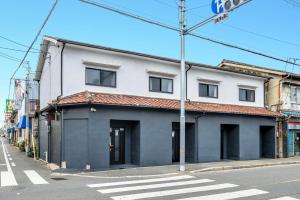 a white building on the side of a street at YAGARA TERRACE HOUSE OSAKA Room D in Osaka