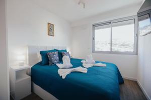 two swans sitting on a blue bed in a bedroom at Atlantic Residence Pool & Ocean View in Câmara de Lobos +46 photos