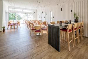 a restaurant with tables and chairs in a room at BB Blick Hotel und Café in Bad Bellingen