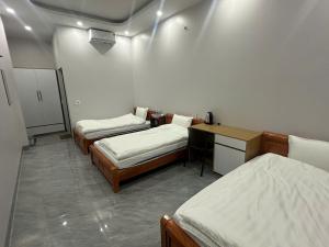 a room with two beds and a desk in it at Trần Hưng Đạo 186 in Na Ngô +8 photos
