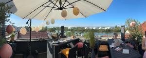 a patio with tables and chairs and an umbrella at Höll am Main in Rüsselsheim