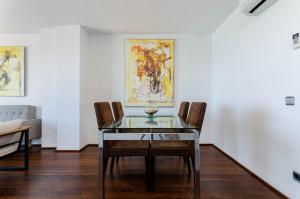 a dining room with a glass table and chairs at Yourhouse Blau Blue 2 3 in Can Picafort
