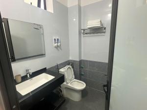 a bathroom with a sink and a toilet and a mirror at Trần Hưng Đạo 186 in Na Ngô