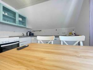 a kitchen with a wooden table and two white chairs at WEN112 gut geschnittene Monteurwohnung in Niederdorla
