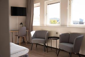a hotel room with two chairs and a table and two windows at Hotell City in Härnösand
