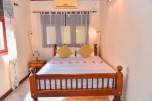 a bedroom with a wooden bed with a window at Niko Villa in Kosgoda +25 photos