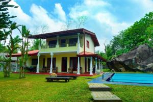 a house with a pool in front of it at Niko Villa in Kosgoda