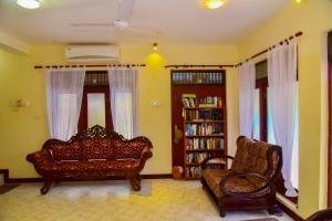 a living room with a couch and a book shelf at Niko Villa in Kosgoda