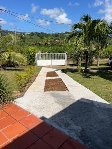 a walkway with a white bench in a yard at Douceur tropicale in Ducos
