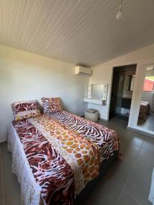 a bedroom with a bed with a comforter on it at Douceur tropicale in Ducos