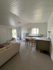 a kitchen and living room with a couch and a table at Douceur tropicale in Ducos
