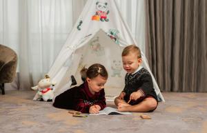 two children sitting on the floor reading a book at Mandarin Oriental, Geneva in Geneva