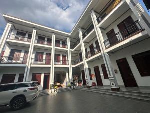 a white car parked in front of a building at Trần Hưng Đạo 186 in Na Ngô