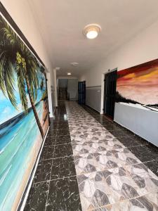 an empty hallway with paintings on the walls at Résidence Yavanie in Kribi