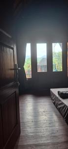a room with three windows and a bed in it at Five Time homestay Syariah in Selaparang