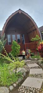 a person standing in front of a small house at Five Time homestay Syariah in Selaparang +6 photos