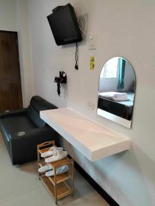 a room with a table and a mirror and a couch at Malee Guesthouse in Ban Rak Thai