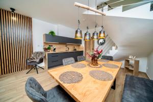 a kitchen and dining room with a wooden table and chairs at Apartmány Na Satině in Malenovice