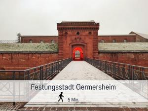 a bridge with a red door with a person walking through it at Germersheimer Rhein-Idylle Sauna, Whirlpool in Germersheim