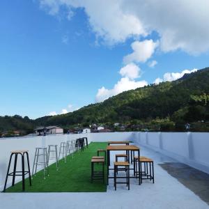 a row of tables and chairs on a roof at Malee Guesthouse in Ban Rak Thai