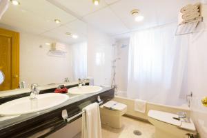 
a bathroom with two sinks and a bathtub at Hotel Eth Solan in Vielha
