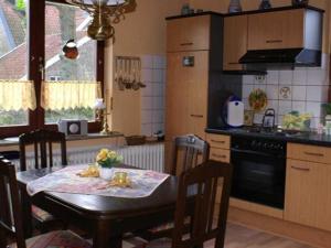 a kitchen with a table with chairs and a stove at Ferienwohnungen Grueßing, 15014 in Leer +17 photos