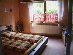 a bedroom with two beds and a window at Ferienwohnungen Grueßing, 15014 in Leer