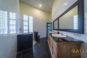 a bathroom with a sink and a mirror at Villa Burung, Bali - Breathtaking oceanfront, infinity pool in Tegallengah +45 photos