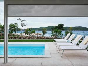 a group of chairs sitting next to a swimming pool at Resort Šibenik in Šibenik