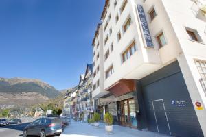 a building on a street with cars parked on the street at Hotel Eth Solan & SPA in Vielha