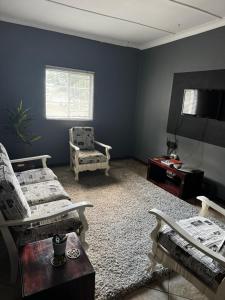 a living room with two couches and a television at Kort a Moi in Lichtenburg