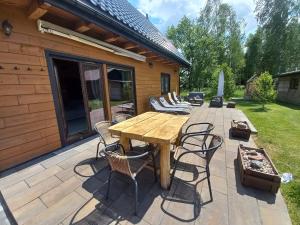 a wooden table and chairs on a patio at Ancuty 20 in Ancuty