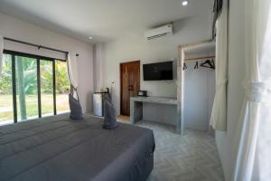 a bedroom with a large bed with a large window at Tonmai Suites III in Ko Lanta