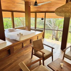 a bedroom in a tree house with a bed and a chair at Tribe Wilpattu - Eco Lodge in Wilpattu +36 photos