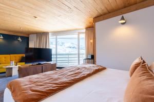 a bedroom with a large bed and a television at Fahrenheit Seven Val Thorens in Val Thorens +101 photos