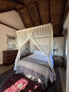 a bedroom with a bed with a canopy at Elands Bay Beach Villa in Elands Bay